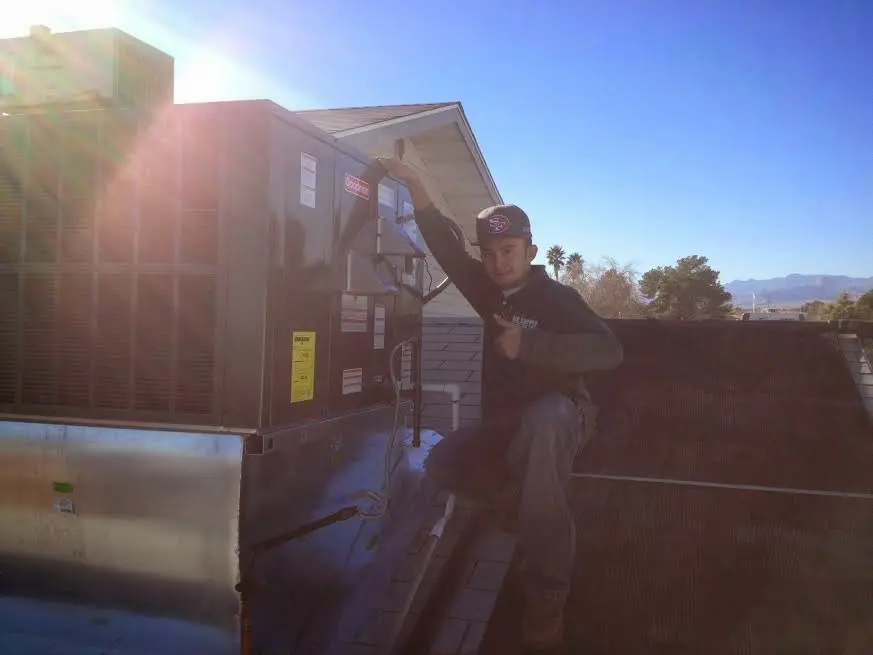 HVAC technician performing Heat Pump Repair on a rooftop unit in Bear Creek